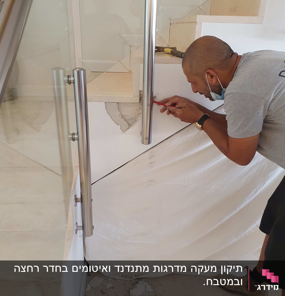 אדם מתקין מעקה מתכת במדרגות עם כלי עבודה